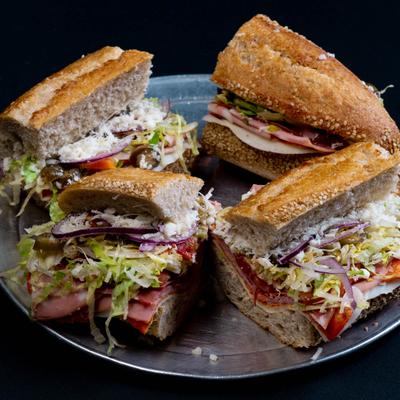 Italian sandwich cut into multiple pieces on a metal tray.