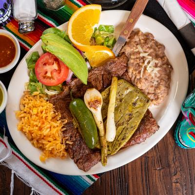 Grilled skirt steak with rice, beans, grilled cactus, jalapeno, and grilled spring onions.