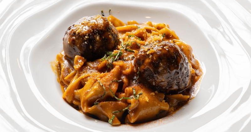 Pasta with two duck meatballs in brown sauce