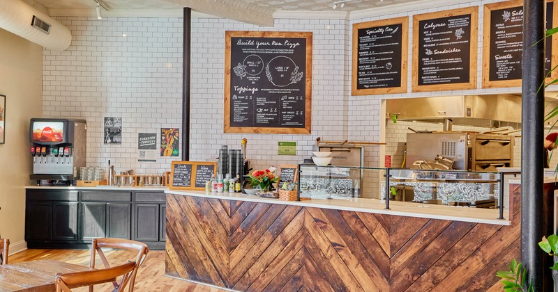 Interior, checkout counter with glass display case, menu boards on the wall, soda fountain