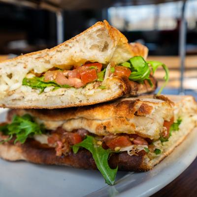 Caprese sandwich sliced in half and stacked on a plate.