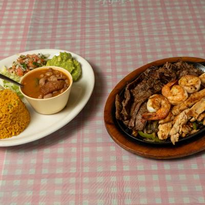 Mixed fajitas skillet served with rice, charro beans, guacamole and pico de gallo.