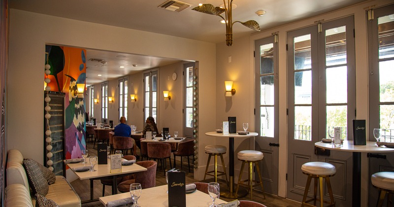 Cozy and modern interior dining area with dining tables set for guests