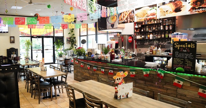 Interior of a lively Mexican style restaurant decorated with hanging paper ornaments