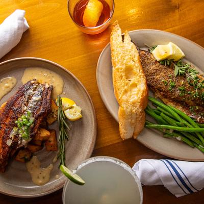 Blackened gulf fish and charbroiled redfish on the half shell plates, top view.
