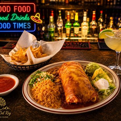 Burrito covered in red sauce, with guacamole, sour cream, tomato salsa, rice, and beans.