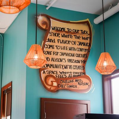 Interior with a welcoming mural on a teal wall and pendant lights.