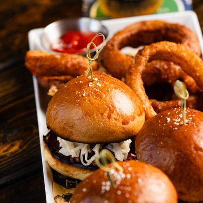 Corned beef sliders with onion rings.