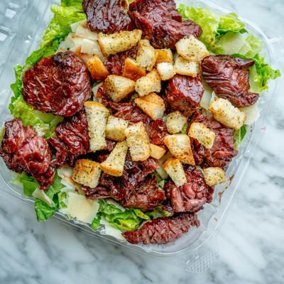 Honey barbecue steak tips Caesar salad with sun-dried tomatoes and croutons.
