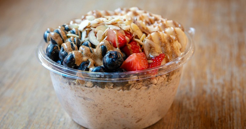 Adding blueberries to acai bowl, close up