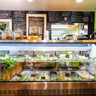 Interior, glass display case with different salads, beverages and dessert bars