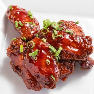 Fried chicken wings topped with a house-made mambo sauce and scallions.
