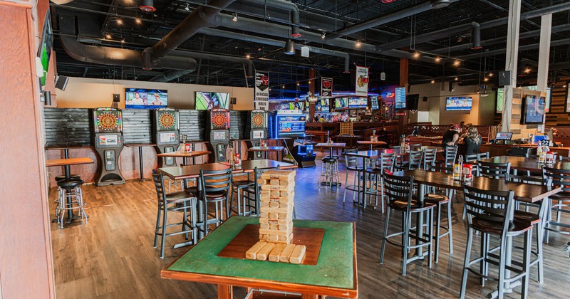 Interior, high seating tables with stools, Jenga game table, electronic darts, TVs