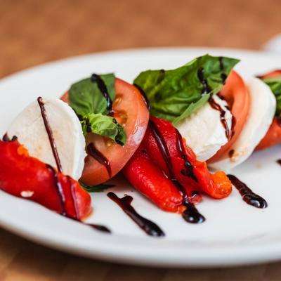 Caprese salad with mozzarella, tomatoes, basil, and balsamic glaze.
