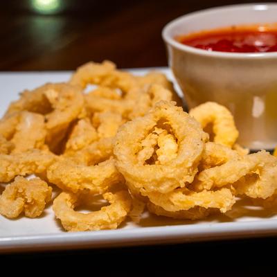 Fried calamari served with a dipping sauce.