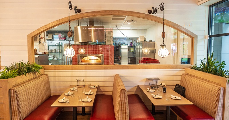 Restaurant interior, dining booths lined up, view into the kitchen