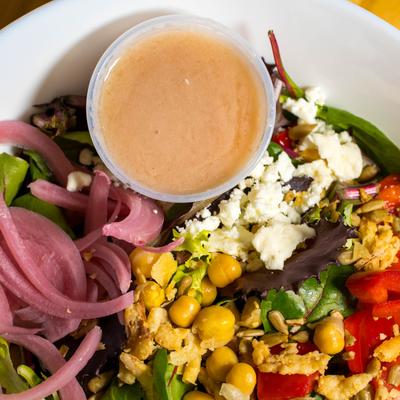 Mixed greens salad with chickpeas, cucumbers, pickled red onions, feta cheese, and vinaigrette.
