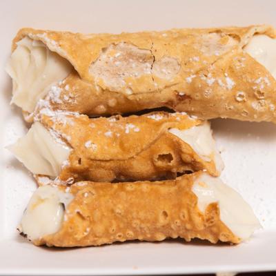 Cannoli with cream filling dusted with powdered sugar.