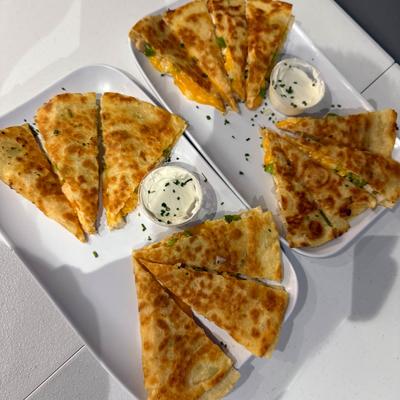Chicken quesadilla served with dipping sauces.