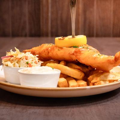 Fish and chips served with tartar sauce and coleslaw.