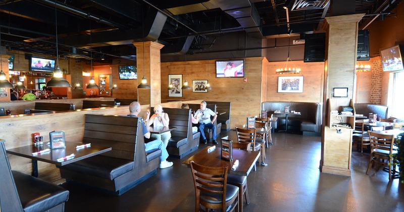 Spacious restaurant interior with wooden booths and tables