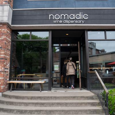 Exterior of Nomadic Wine Dispensary with a modern brick facade and entrance.