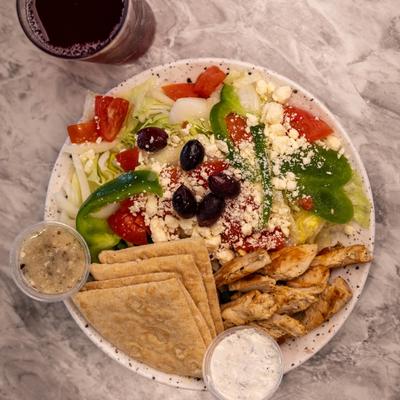 Greek Chicken Platter with Greek Salad, Pita Bread, and Homemade Tzatziki Sauce.