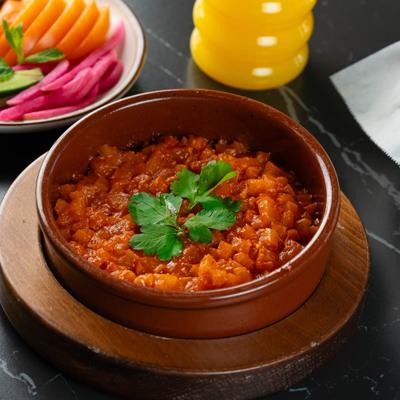 Stewed tomatoes  with parsley garnish and a side of pickled veggies.