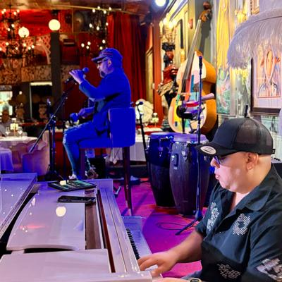 A pianist and the bolero singer called el turco on the stage, singing.