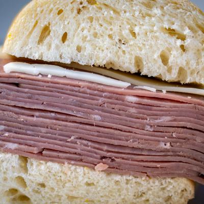 Roast beef sandwich topped with cheese, close-up.