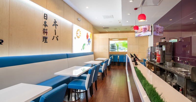 Interior, tables lined up on one side and the restaurant counter on the other