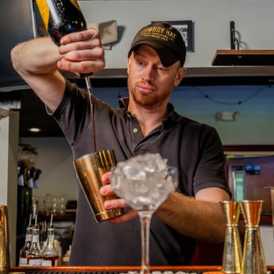 A person preparing a cocktail.