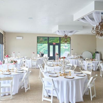 Interior, wedding venue. reception room set for dining.