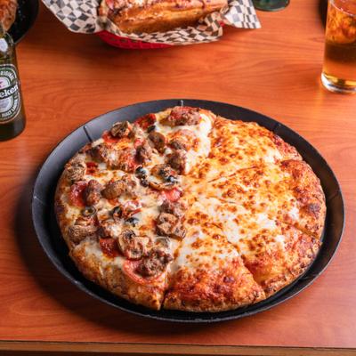 Whole split-top pizza with various toppings on one and plain cheese on the other half.