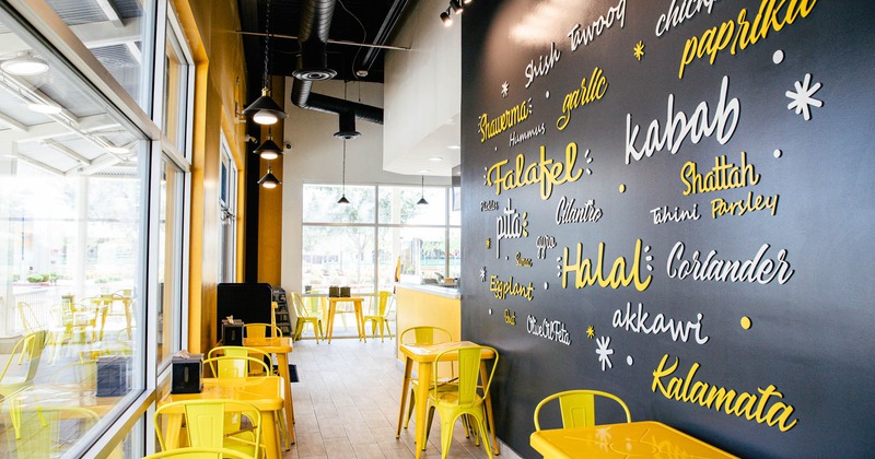 Interior, yellow tables and chairs, decorative writings on the wall in different fonts