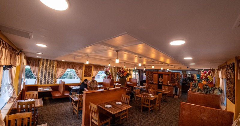 Spacious interior dining area with wooden booths, tables and chairs