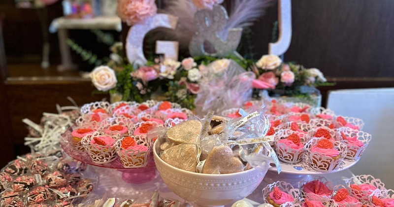 Dessert table with pink cupcakes and wrapped treats