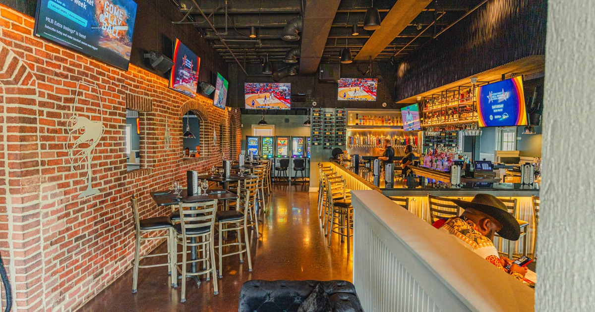 Interior, tables and chairs lined up on the left, bar and bar stools on the right