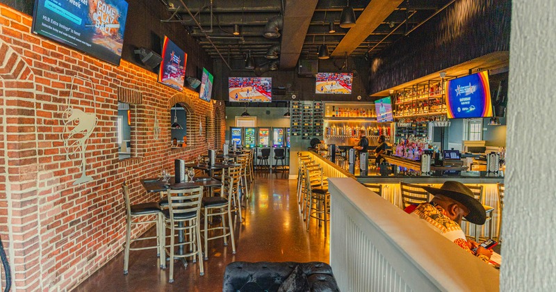 Interior, tables and chairs lined up on the left, bar and bar stools on the right