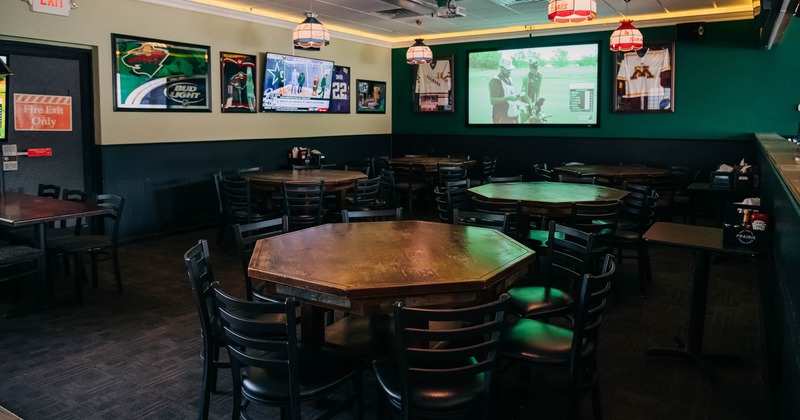 Interior, octagonal tables, chairs, tv screens on the wall