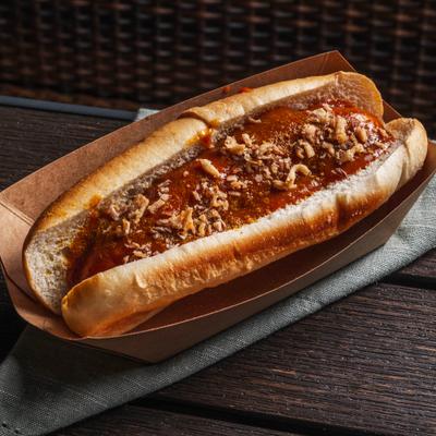 Currywurst Roll served in a paper food tray, topped with sauce and crispy onions.