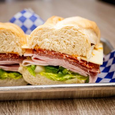 Salami and ham sandwich with cheese, lettuce, and green peppers.