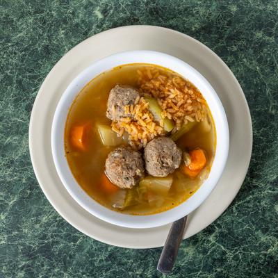 Meatball soup with carrots, rice, and potatoes.