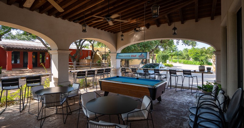 Covered patio seating area with a pool table