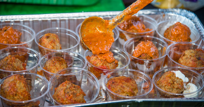 Staff member serving food portions for customers to pick up