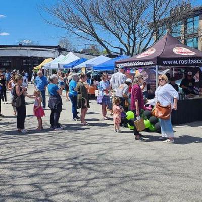 Customers waiting in a queue in front of Rosita's Cocina food stand on a sunny day.