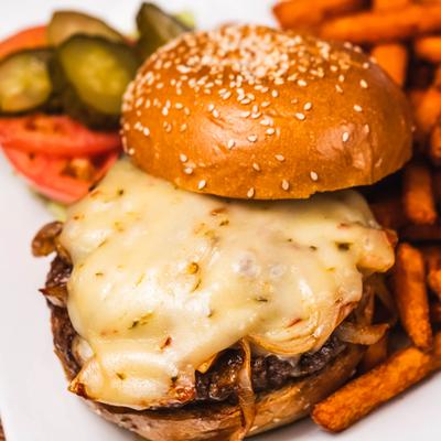 Cheeseburger served with sweet potato fries and a small salad.
