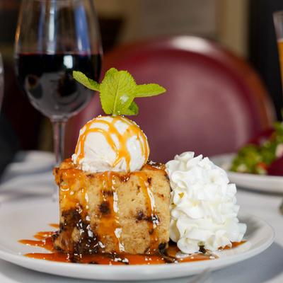 Bread pudding with whipped cream and ice cream.