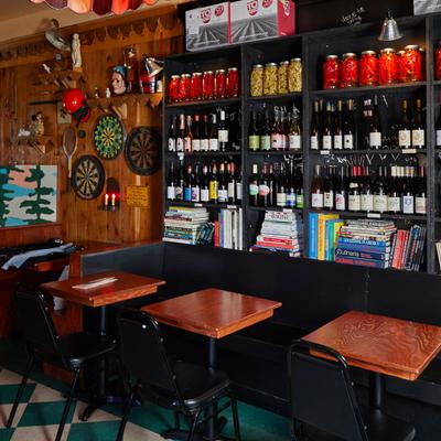Seating area, various books, bottles and jars on the shelf.