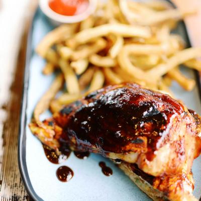 Barbecue chicken with fries on a plate.